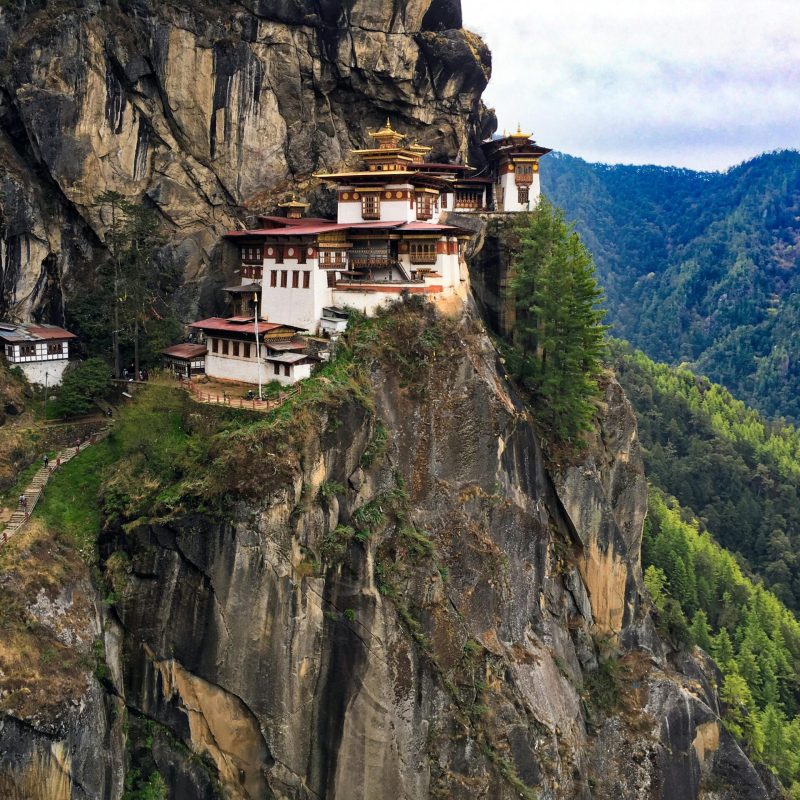 A breathtaking view of the iconic Tiger's Nest Monastery perched on a cliff in Bhutan's lush landscape.